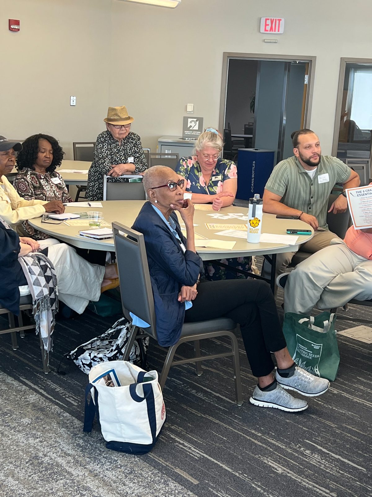 Fredericka Wallace Deena seated at a round table during a workshop session with other participants.